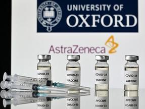 Esta fotografia de arquivo, tirada em 17 de novembro de 2020, mostra uma ilustração de frascos com adesivos Covid-19 Vaccine colados e seringas, com o logotipo da Universidade de Oxford e sua parceira farmacêutica britânica AstraZeneca, em Londres.