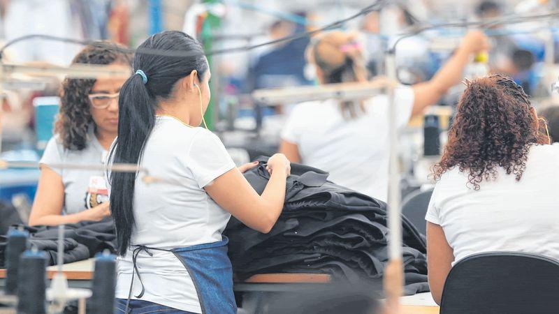 mulheres trabalhando em fábrica de roupas