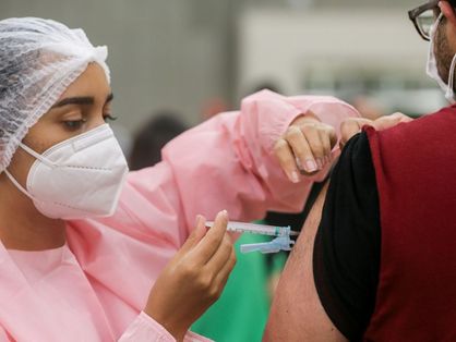 Enfermeira vacinando homem contra covid-19
