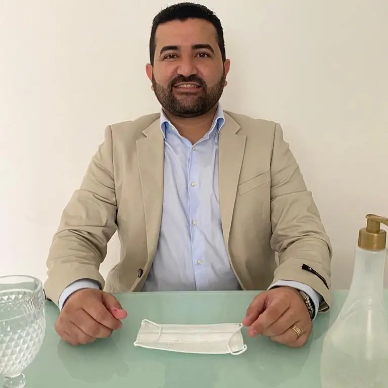 Esta é a imagem do prefeito do município de catarina Thiago Paes de Andrade sentado em uma mesa sorrindo