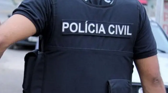 Esta imagem mostra um policial civil de costas ao lado de uma viatura no município de Icó