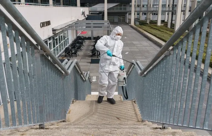 Esta imagem mostra um homem usando equipamentos de segurança limpando uma escada na Espanha em meio a segunda onda de covid-19 no país