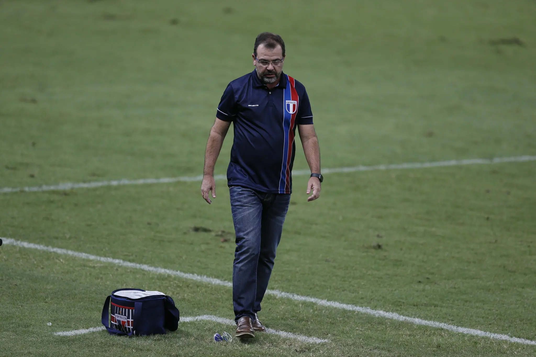 Enderson Moreira cabisbaixo na beira do campo