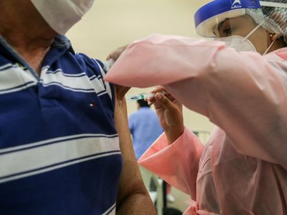 Profissional de saúde vacina idoso no Ceará