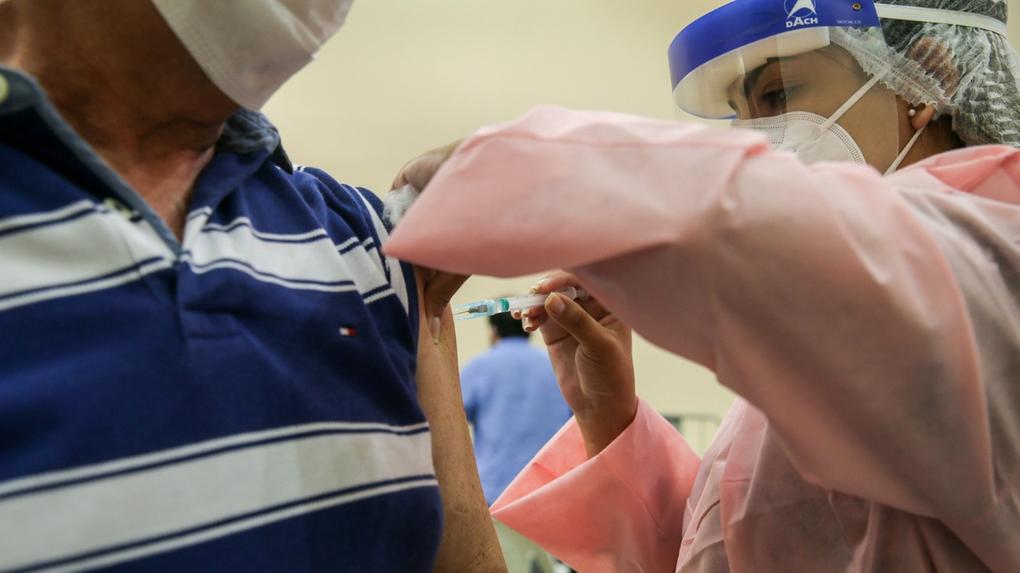 Profissional de saúde vacina idoso no Ceará