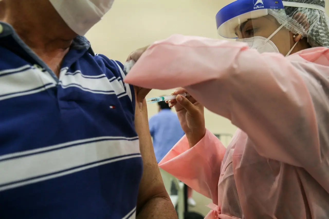 Profissional de saúde vacina idoso no Ceará