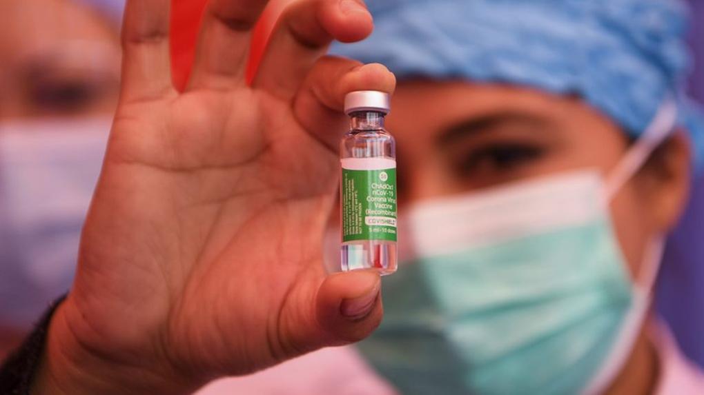 Enfermeira segurando frasco de vacina contra a Covid-19