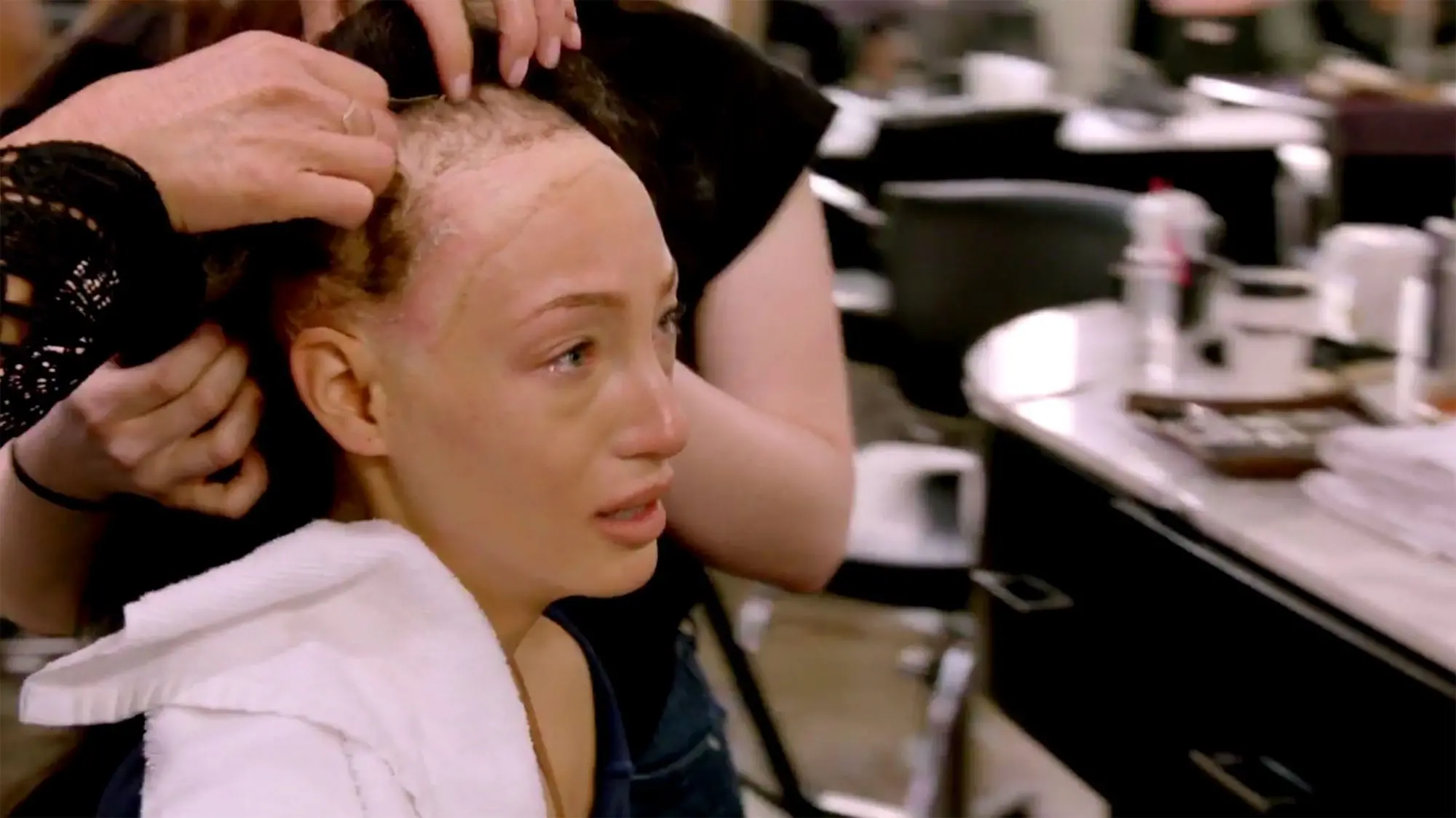 Jeane Turner tendo sua peruca removida