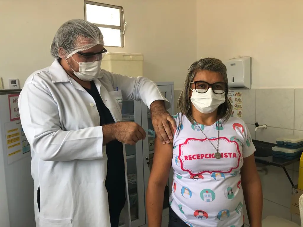 Técnico de enfermagem com seringa na mão vacina profissional da saúde contra Covid-19 no interior do Ceará