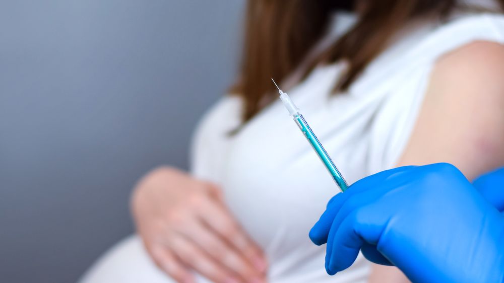 Mulher grávida tomando vacina contra Covid-19