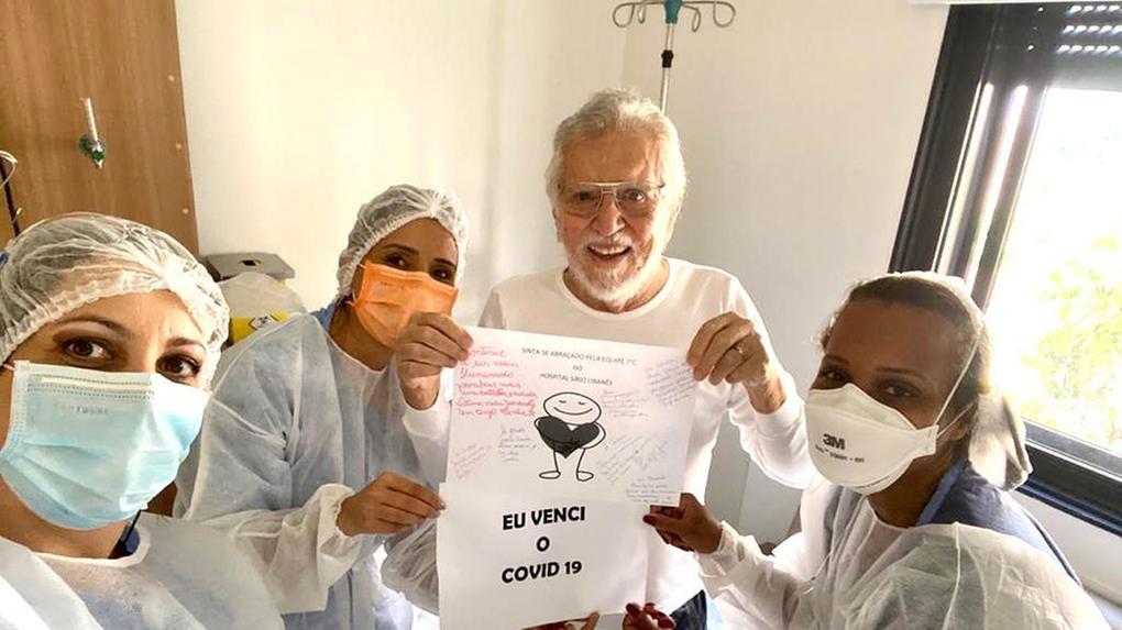 Carlos Alberto de Nóbrega segura papel com mensagens de carinho ao lado de enfermeiras