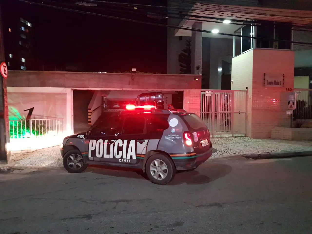 Carro de polícia em frente a um condomínio
