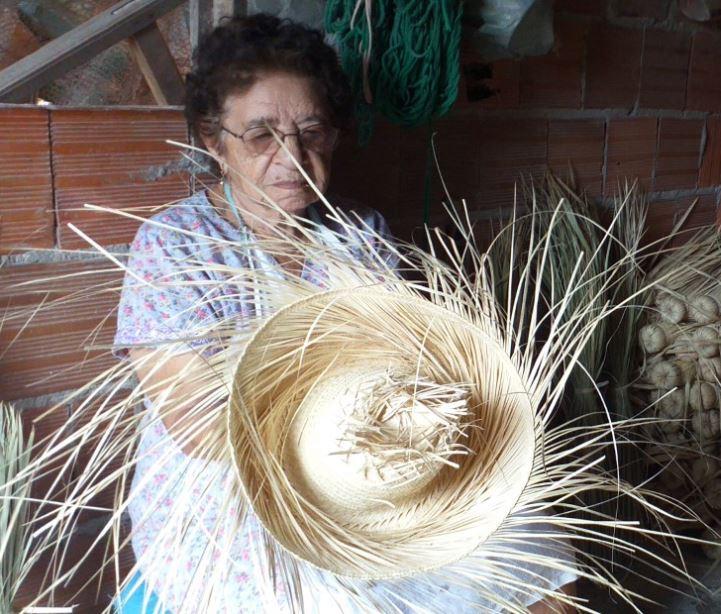 Maria Marcos dos Santos mostra chapéu feito de palha de carnaúba