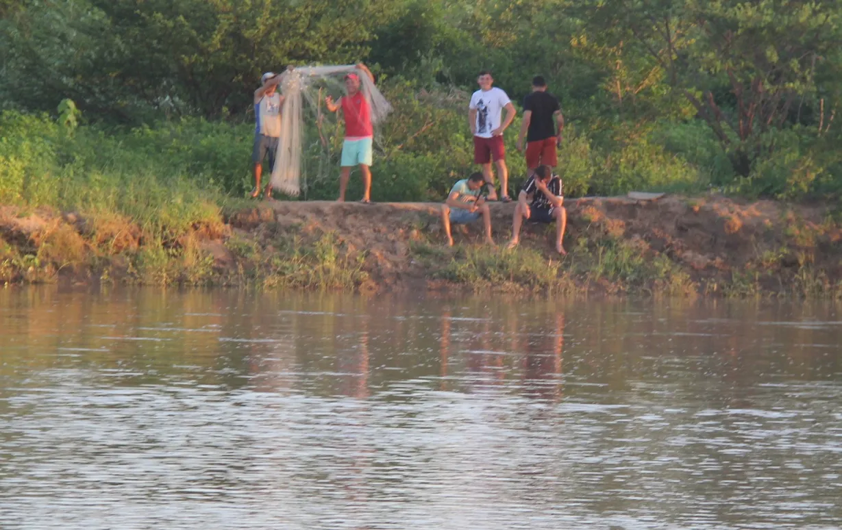 Jovens exibem rede usada para a pesca ilegal