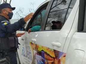 Agente da Guarda Municipal de Camocim orienta turista em barreira sanitária implantada na fronteira da cidade