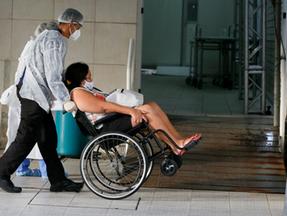 Paciente com Covid-19 levada em cadeira de rodas em Caucaia
