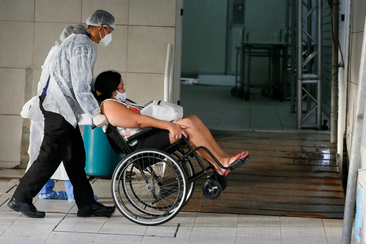 Paciente com Covid-19 levada em cadeira de rodas em Caucaia