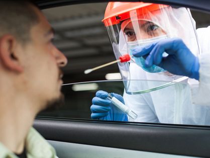 Trabalhador médico do Reino Unido realizando verificação de drive-thru COVID-19, colhendo amostra de espécime de esfregaço nasal de paciente masculino através da janela do carro, diagnóstico de PCR para presença de Coronavírus