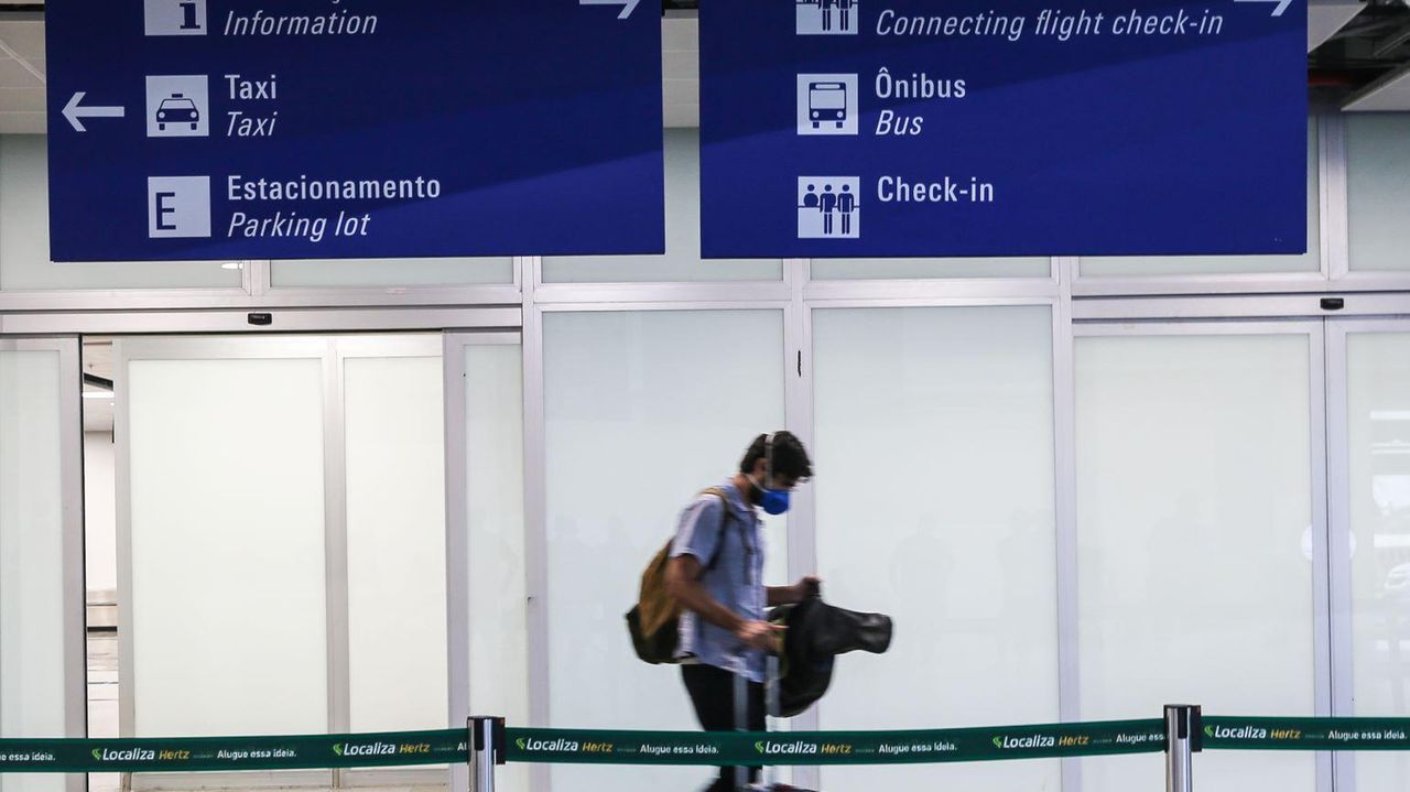 Passageiro transita em aeroporto com máscara