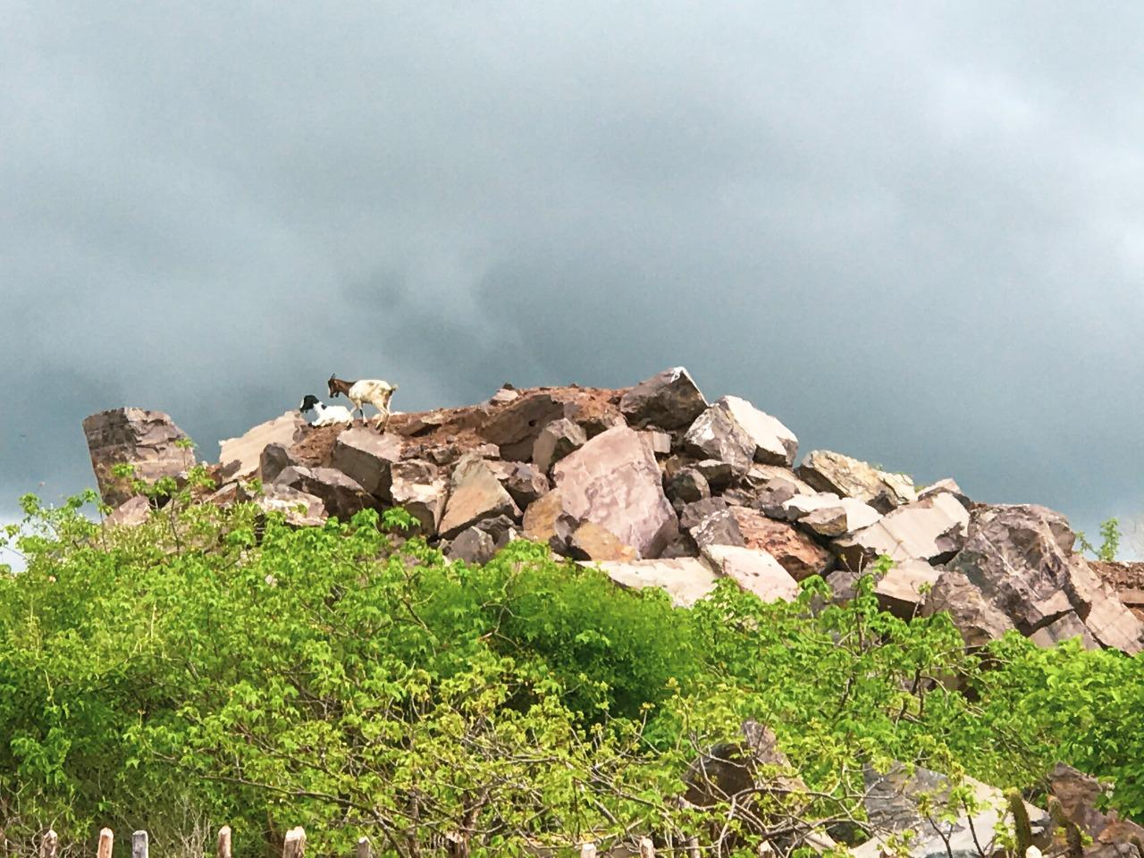 Uma nuvem “carregada” em cima de um morro de pedras gigantes e arredondadas