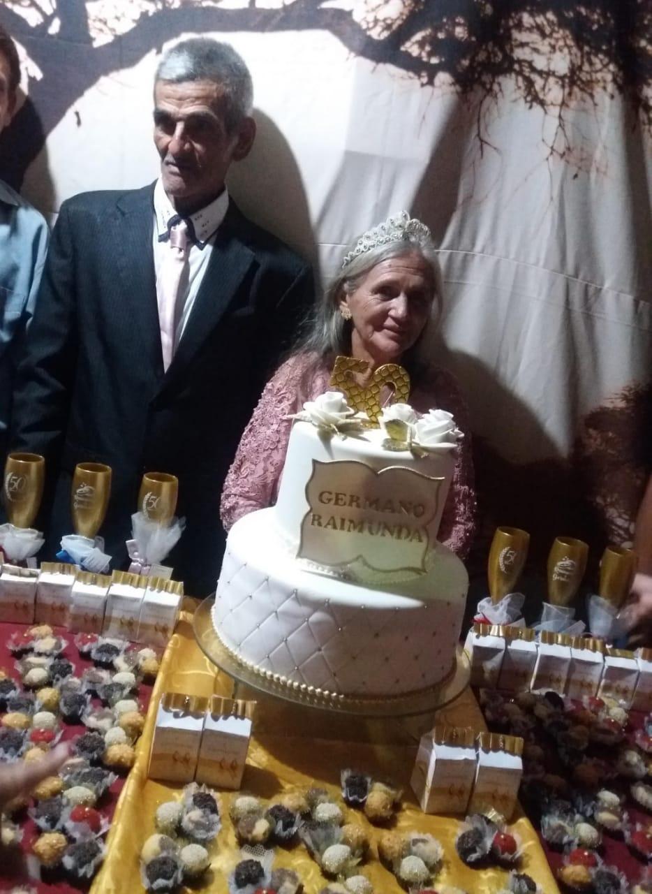 José e Raimunda posando para foto junto de bolo de aniversário de casamento do casal