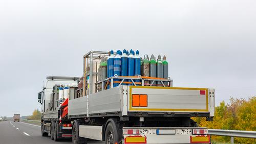 Transporte de cilindros com oxigênio para pacientes com coronavírus. Caminhão entregando botijões de gás para fins médicos