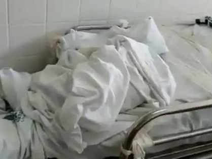 Corpo de vítima da Covid-19 enrolada em panos, sobre uma maca em hospital do Distrito Federal
