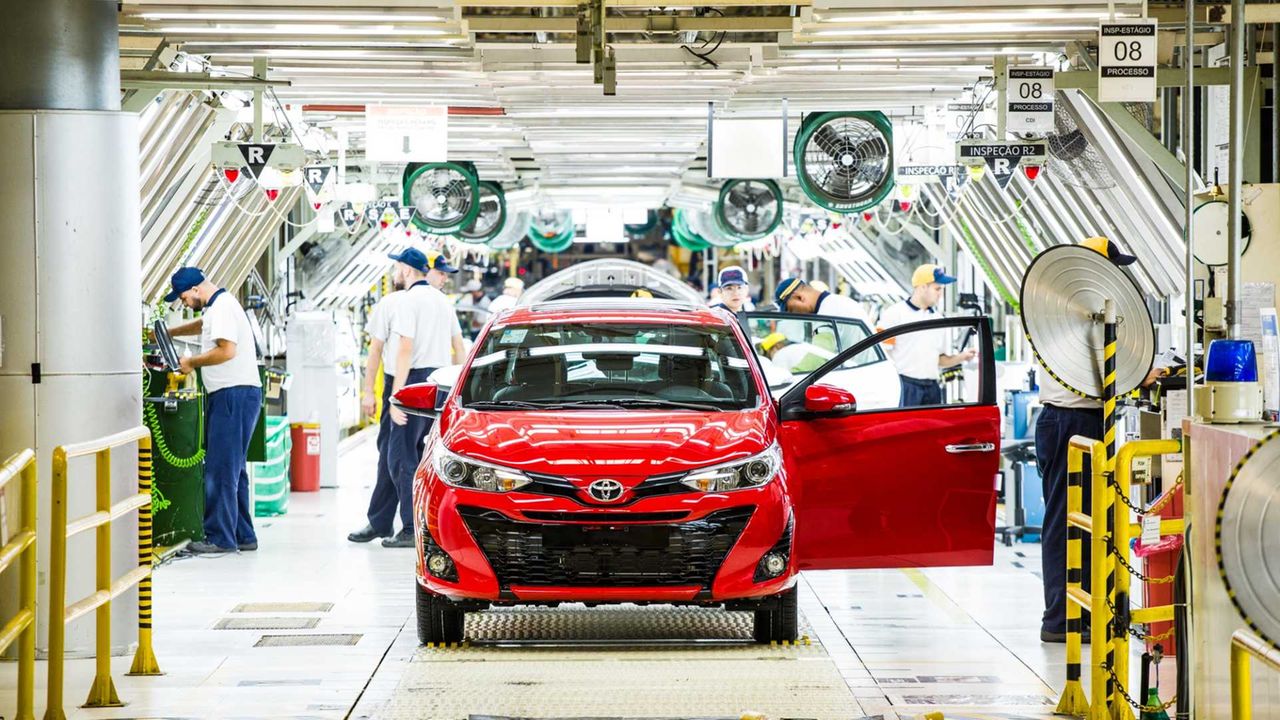 Imagem mostra um carro vermelho em uma linha de produção da fábrica da Toyota no Brasil