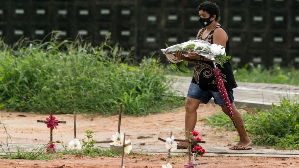 Mulher leva flores ao cemitério
