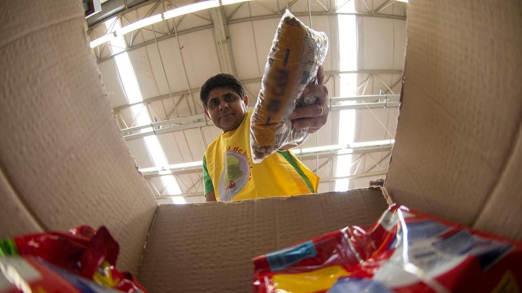 Homem em supermercado reúne itens da cesta básica
