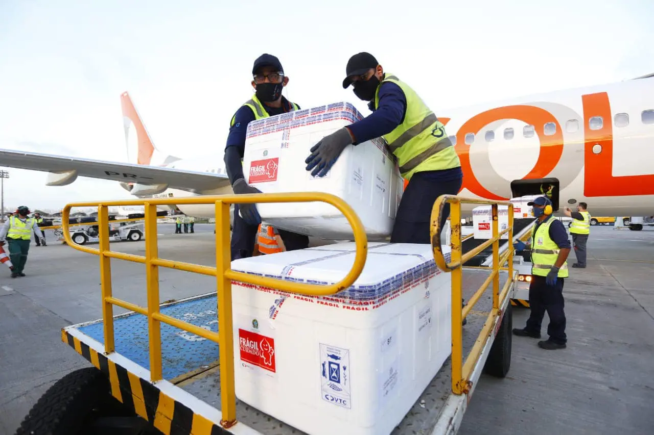 Funcionários carregando lotes de vacina contra a Covid-19, que chegaram em Fortaleza