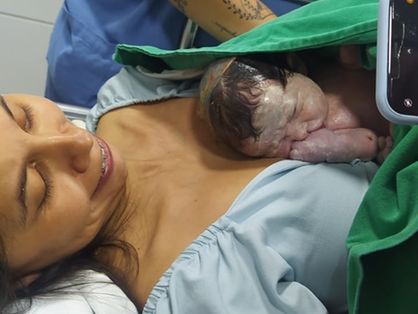 Mulher com criança após parto realizado por policiais no Montese