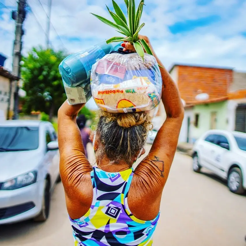 Mulher carrega cesta básica no Ceará