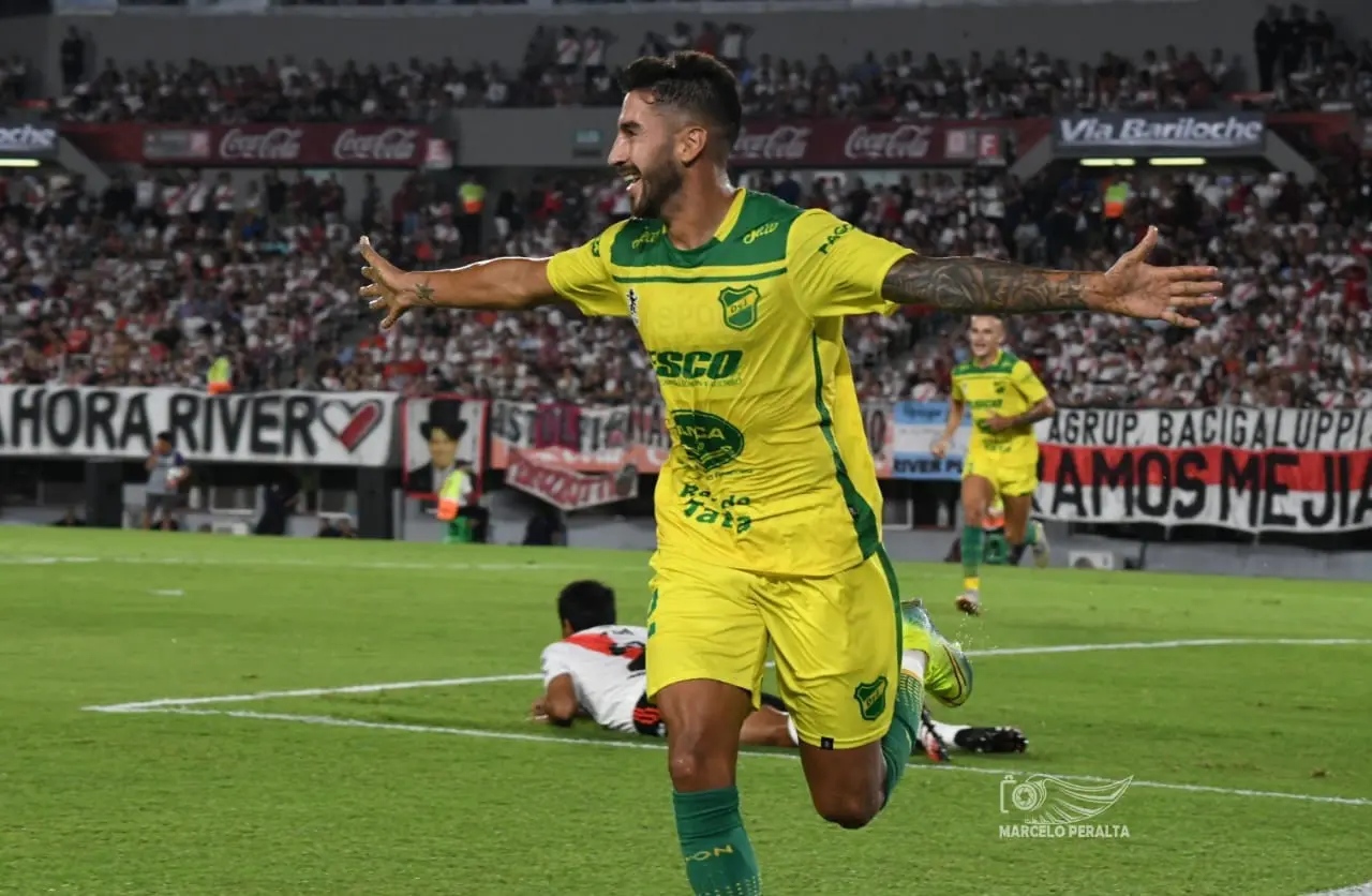 Atleta comemora gol com os dois braços abertos e sorri