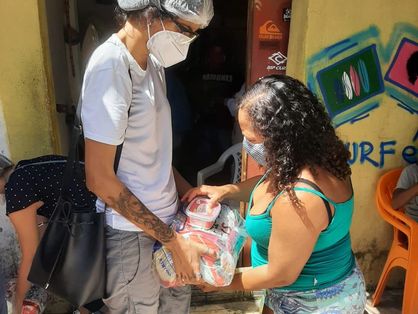 Na última ação promovida pelo Onda Solidária, na Barra do Ceará, a advogada e surfista Tayane Sales (à esq., de branco) entregou cestas básicas.