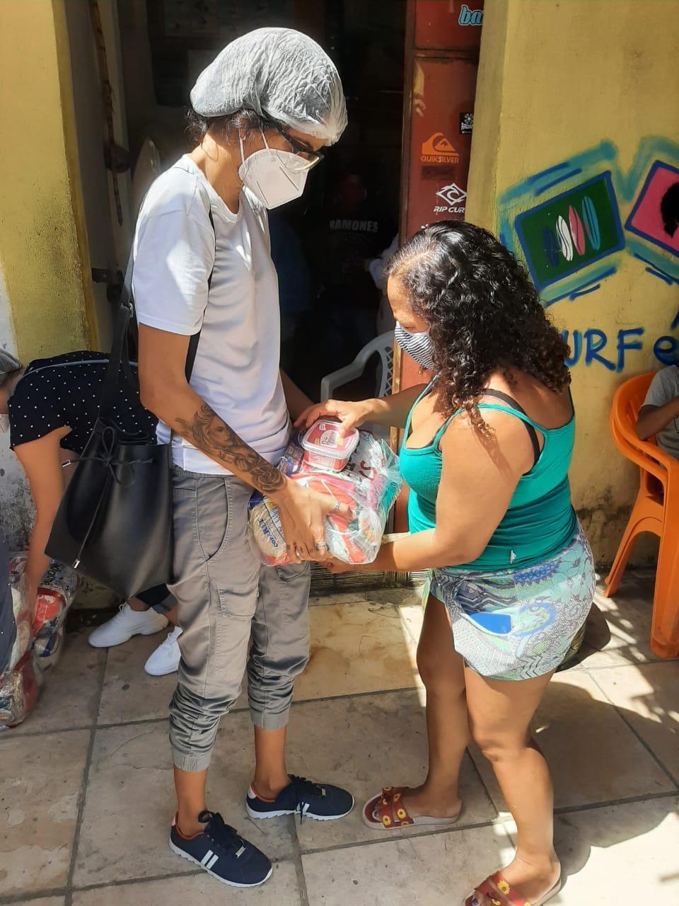 Na última ação promovida pelo Onda Solidária, na Barra do Ceará, a advogada e surfista Tayane Sales (à esq., de branco) entregou cestas básicas.