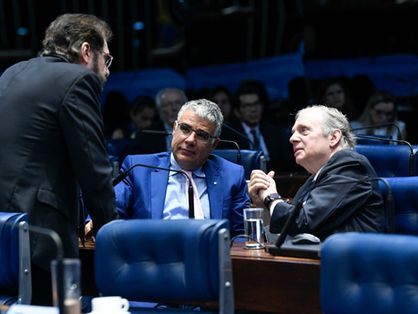 Senadores Tasso Jereissati e Eduardo Girão conversam com outro senador, que está de costas, no plenário do Senado