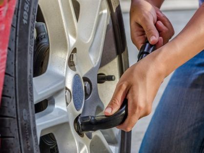 foto de pessoa trocando pneu de carro