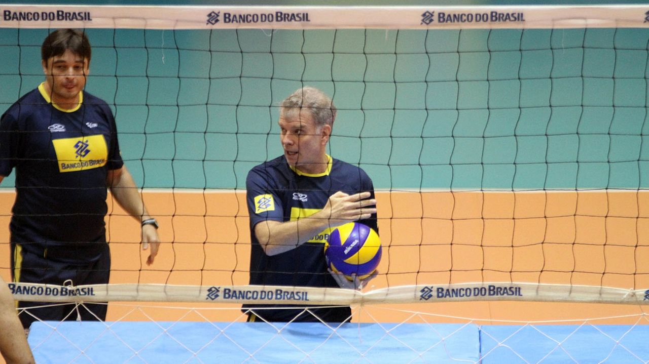 Ex-técnico de vôlei do Brasil Bernardinho atrás de uma rede de vôley segurando uma bola