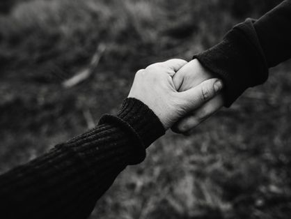 Duas mãos ligadas uma à outra, em preto e branco
