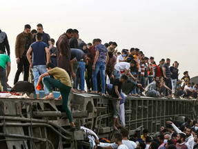 Pessoas após acidente de trem no Egito