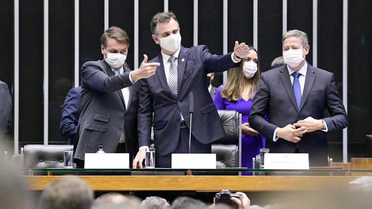 Presidente Jair Bolsonaro ao lado de Rodrigo Pacheco e Arthur Lira no Congresso. Pacheco e Bolsonaro apontam para a direita, com o presidente da República fazendo 