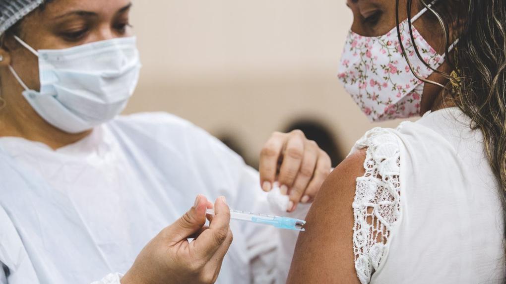 Profissional de saúde vacinando pessoa contra a Covid-19 em Fortaleza