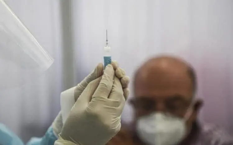 Profissional se preparando para vacinar idoso