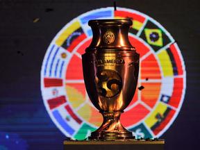 Taça da Copa América na frente das bandeiras das seleções da América do Sul