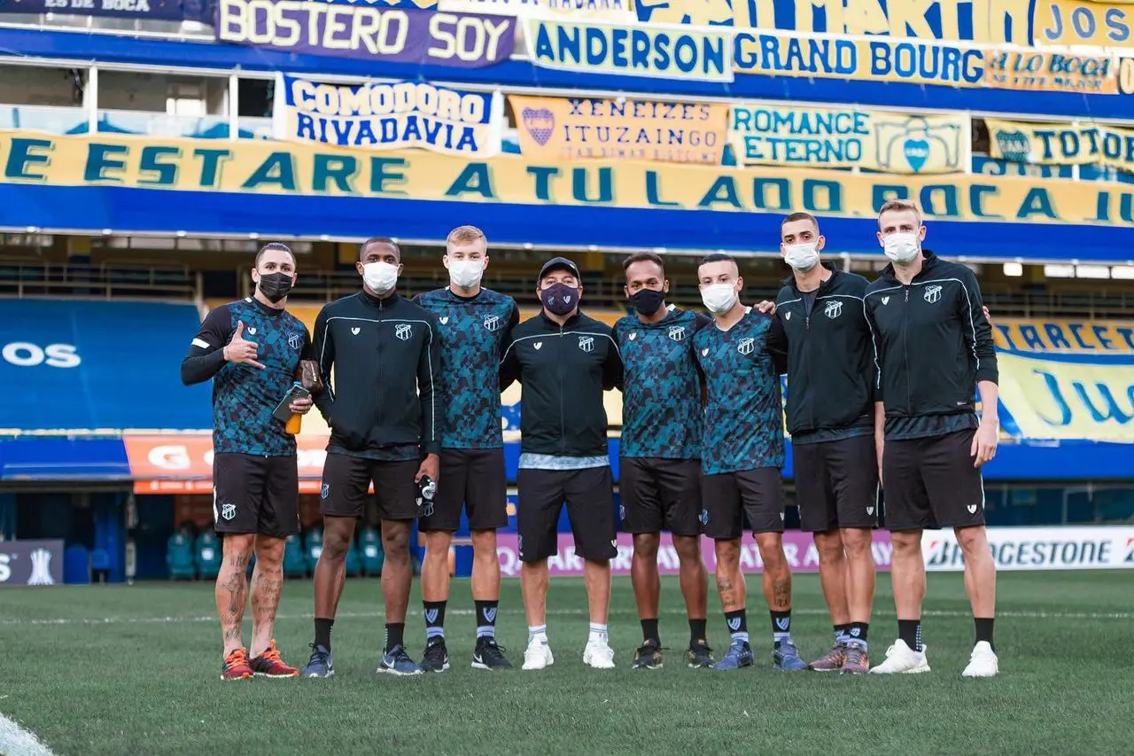Delegação do Ceará abraçada na frente de faixas da torcida do Boca Juniors