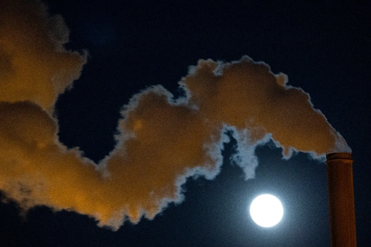 A Lua Super Rosa surgindo quando um forte vento sopra vapor escapando da Instalação Geotérmica de Leathers, uma usina que explora o calor subterrâneo profundo perto do Mar de Salton, no extremo sul da Falha de San Andreas, em 26 de abril de 2021. perto de Calipatria, na Califórnia