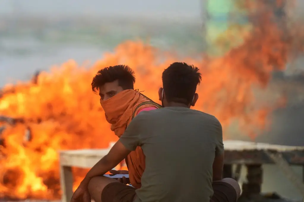 Duas pessoas durante cremação de mortos por Covid-19 na Índia