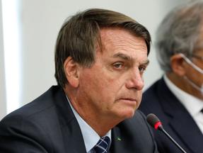 Presidente Jair Bolsonaro ao lado de ministro da Economia, Paulo Guedes, ao fundo