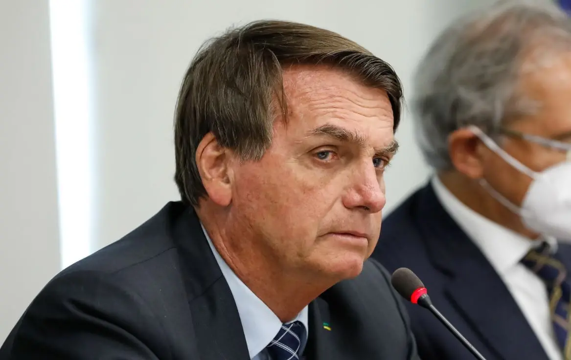 Presidente Jair Bolsonaro ao lado de ministro da Economia, Paulo Guedes, ao fundo